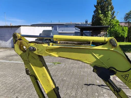 Baumaschinen reinigen am Minibagger: derselbe Ausleger nach dem Trockeneisstrahlen, Fett und Altöl entfernt