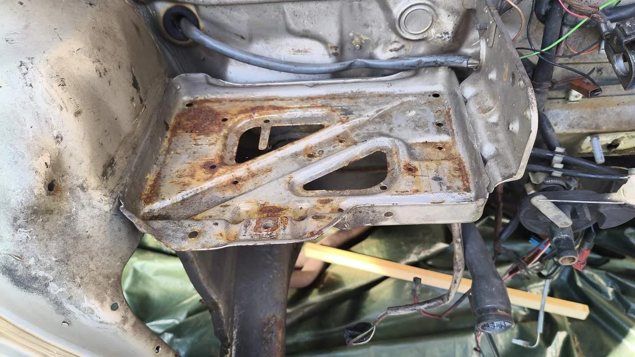 Motorraum reinigen Kosten, Preisfaktor Zustand: verschmutzte Batteriekonsole mit alter Schmutzschicht und Rost im Oldtimer