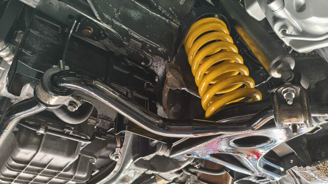 Unterbodenreinigung am Auto, Endergebnis: frisch gewachster Unterboden des C55 AMG mit gelben Federn